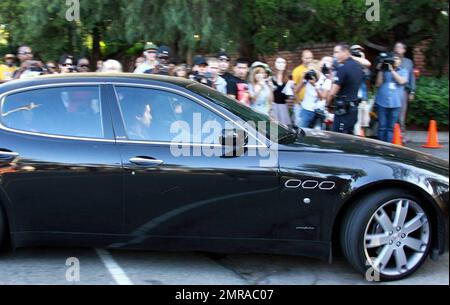 Fans and friends gather outside the Jackson family compound to leave flowers and gifts and pay their respects as the family arrives from UCLA Medical Center where Michael Jackson was pronounced dead after suffering from cardiac arrest this afternoon. Encino, CA. 6/25/09. . Stock Photo