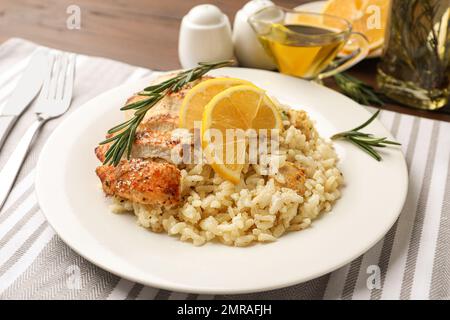 Delicious chicken risotto with lemon slices on table Stock Photo