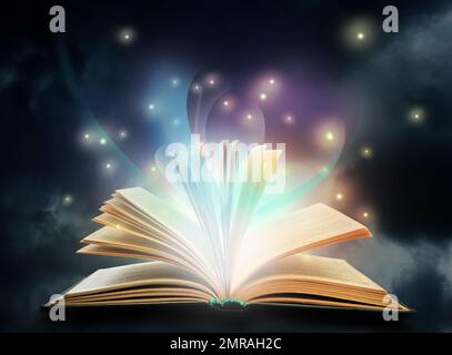Open book with fairytales and magic lights. Creative design Stock Photo