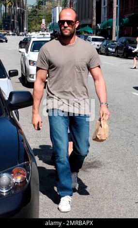 Action star Jason Statham, who is currently filming 'The Mechanic', looks a bit scruffy while carrying a brown paper bag after leaving a medical building on Bedford Drive. Los Angeles, CA. 03/18/10.   . Stock Photo