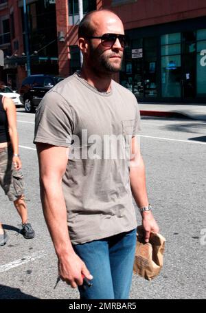 Action star Jason Statham, who is currently filming 'The Mechanic', looks a bit scruffy while carrying a brown paper bag after leaving a medical building on Bedford Drive. Los Angeles, CA. 03/18/10.   . Stock Photo