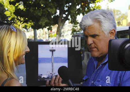 Jay Leno shows a passerby photos of some of the world's most well known landmarks while filming the popular segment 'Jaywalking' for 'The Tonight Show with Jay Leno.' West Hollywood, CA. 8/5/10.   . Stock Photo