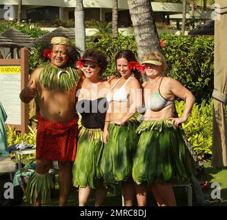 EXCLUSIVE!! With a tropical flower in her hair Jennifer Love Hewitt, 31, beamed in the Hawaiian sunlight as she and boyfriend of six months Alex Beh, 27, hugged and enjoyed the afternoon on New Year's Day in what appeared to be a gathering of friends and family, including her mom Pat who wore a black bathing suit, at their hotel. Showing off her natural curves Jennifer looked lovely in a white bikini and traditional hula skirt made of leaves. Maui, HI. 01/01/11. Stock Photo