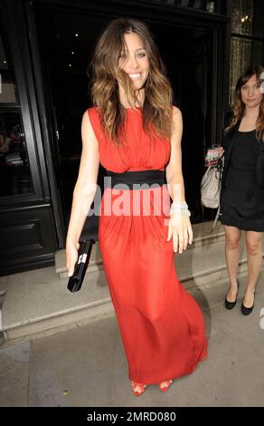 Very happy looking actress Jessica Biel is eye-catching in a stunning long red see through gown as she leaves her London hotel, heading to the premiere of 'The A-Team' held at Leicester Square.  While her boyfriend Justin Timberlake is in New York filming 'Friends with Benefits' co-starring Mila Kunis, Biel seems to be standing out across the pond thanks to her choice of wardrobe. London, UK. 07/27/10. Stock Photo