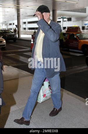 EXCLUSIVE!! Legendary UK actor, writer and comedian John Cleese, famous for appearances and writing in TV series and films including 'Monty Python's Flying Circus,' 'Fawlty Towers, 'Shrek' and 'Will & Grace,' arrives at Miami International Airport to catch a flight. Cleese made sure to take what looked to be a new Apple laptop computer out of his luggage, placing it in a carry-on bag. Miami, FL. 3/10/11. Stock Photo