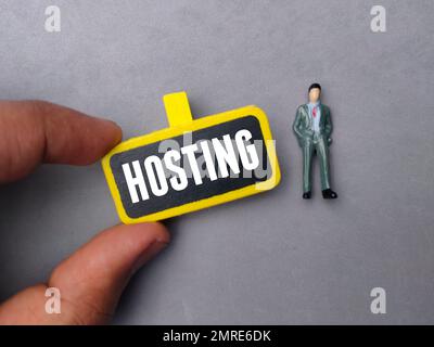 Hand holding colored board with the word HOSTING Stock Photo