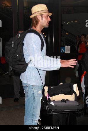 'Lost' actor Josh Holloway at LAX with wife Yessica Kumala and their one-year-old daughter Java after a flight in from Hawaii.  Josh seemed very happy as he smiled for fans while Yessica carried little Java. Los Angeles, CA. 04/26/10.   B Stock Photo