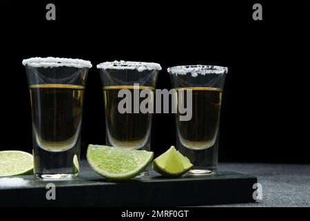 Mexican Tequila shots with lime slices and salt on table Stock Photo