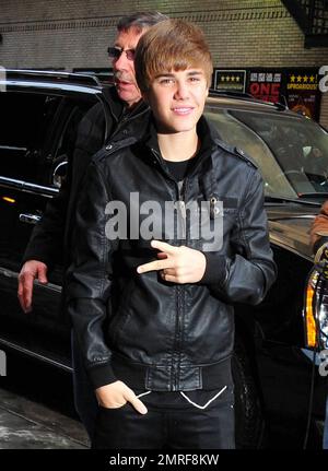 Teen Heartthrob Justin Bieber flashes a peace sign as he arrives at the  