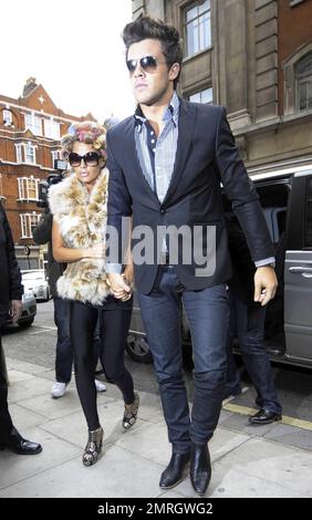 Katie Price and new boyfriend, model Leandro Penna, leave BBC Radio 2. With her hair in curlers, Katie (aka Jordan) wore a fur vest, black leggings and some funky skull-patterned high heels as the two left the building hand-in-hand. Katie, who recently split from husband Alex Reid after less than a year of marriage, has reportedly signed a $1.3 million deal to host a new reality series called 'Make Me a Hunk,' in which she will help to transform 'nerdy' men into hunks. London, UK. 3/22/11. Stock Photo