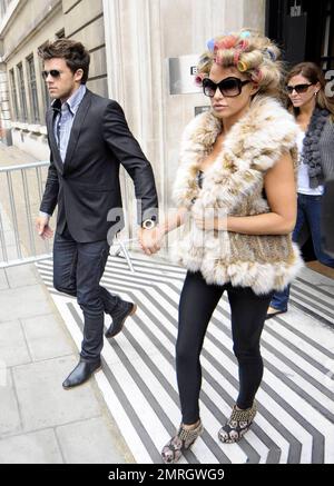 Katie Price and new boyfriend, model Leandro Penna, leave BBC Radio 2. With her hair in curlers, Katie (aka Jordan) wore a fur vest, black leggings and some funky skull-patterned high heels as the two left the building hand-in-hand. Katie, who recently split from husband Alex Reid after less than a year of marriage, has reportedly signed a $1.3 million deal to host a new reality series called 'Make Me a Hunk,' in which she will help to transform 'nerdy' men into hunks. London, UK. 3/22/11. Stock Photo