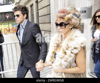 Katie Price and new boyfriend, model Leandro Penna, leave BBC Radio 2. With her hair in curlers, Katie (aka Jordan) wore a fur vest, black leggings and some funky skull-patterned high heels as the two left the building hand-in-hand. Katie, who recently split from husband Alex Reid after less than a year of marriage, has reportedly signed a $1.3 million deal to host a new reality series called 'Make Me a Hunk,' in which she will help to transform 'nerdy' men into hunks. London, UK. 3/22/11. Stock Photo