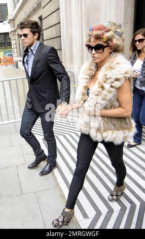 Katie Price and new boyfriend, model Leandro Penna, leave BBC Radio 2. With her hair in curlers, Katie (aka Jordan) wore a fur vest, black leggings and some funky skull-patterned high heels as the two left the building hand-in-hand. Katie, who recently split from husband Alex Reid after less than a year of marriage, has reportedly signed a $1.3 million deal to host a new reality series called 'Make Me a Hunk,' in which she will help to transform 'nerdy' men into hunks. London, UK. 3/22/11. Stock Photo