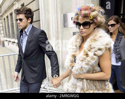 Katie Price and new boyfriend, model Leandro Penna, leave BBC Radio 2. With her hair in curlers, Katie (aka Jordan) wore a fur vest, black leggings and some funky skull-patterned high heels as the two left the building hand-in-hand. Katie, who recently split from husband Alex Reid after less than a year of marriage, has reportedly signed a $1.3 million deal to host a new reality series called 'Make Me a Hunk,' in which she will help to transform 'nerdy' men into hunks. London, UK. 3/22/11. Stock Photo