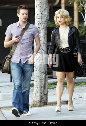 Kelly Osbourne looks cute in a black skirt, white lace top and a black leather jacket as she strolls with a friend in Los Angeles, CA. 2/9/11. Stock Photo