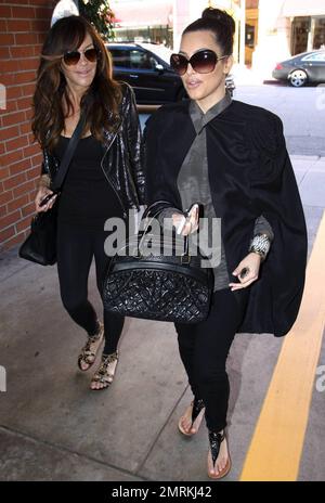 Wearing a black cape over her grey top and carrying a black Louis Vuitton  handbag, Kim Kardashian is joined by Pussycat Dolls founder Robin Antin for  a day of luxury. The two