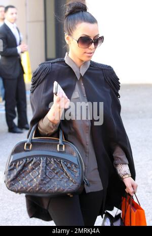 Wearing a black cape over her grey top and carrying a black Louis Vuitton  handbag, Kim Kardashian is joined by Pussycat Dolls founder Robin Antin for  a day of luxury. The two