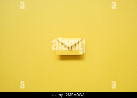 Yellow card envelope on yellow background. top view, copy space, minimalism Stock Photo