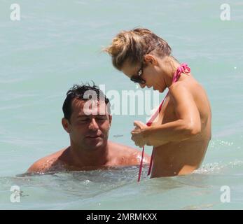 EXCLUSIVE!! Beautiful model, Joanna Krupa, is rescued by her fiancŽ Romain  Zago when her pink bikini top came undone during a dip in the ocean. Zago  helped her to do the bikini