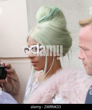 Lady Gaga greets a throng of adoring fans and photographers as she leaves her London hotel and heads off to the ITV studios. Gaga wore a revealing white lace dress with a white skirt underneath, green high heels with matching accented green hair. Gaga paused before she entered her car to blow kisses to her fans. London, UK. 5th October 2011. Stock Photo