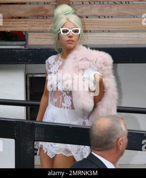 Lady Gaga greets a throng of adoring fans and photographers as she leaves her London hotel and heads off to the ITV studios. Gaga wore a revealing white lace dress with a white skirt underneath, green high heels with matching accented green hair. Gaga paused before she entered her car to blow kisses to her fans. London, UK. 5th October 2011. Stock Photo