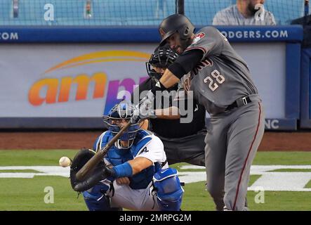 Arizona Diamondbacks' J.D. Martinez, left, runs to first as he hits a solo  home run while Los Angeles Dodgers relief pitcher Josh Fields watches  during the eighth inning of a baseball game