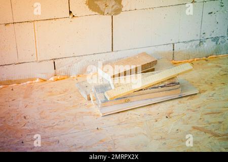 Trimmings of wooden boards at a construction site. Remains of wooden building materials on the OSB floor. Stock Photo