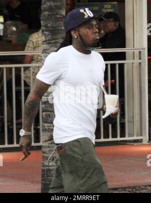 EXCLUSIVE!! Rapper and ex-convict Lil Wayne smokes a cigar and carries a  drink while out on the streets of Miami Beach. The tattooed singer, who was  released from New York's Rikers Island prison last November, later got in  to a chauffeur driven car ...