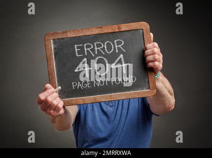 Page not found 404 error - white chalk text on a slate blackboard held by a person, HTTP status code Stock Photo