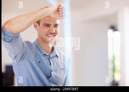 Young man looking out through glass. Portrait of smiling young man looking out through glass. Stock Photo