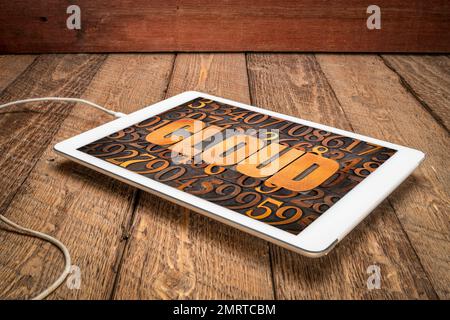 cloud computing concept - word in vintage letterpress wood type against numbers on a digital tablet Stock Photo