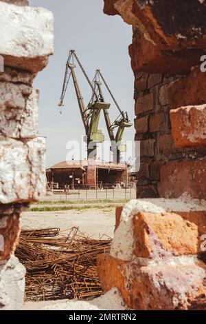 Gdansk, Poland - July 19 2022: Industrial building at the Gdansk Shipyard, former Lenin Shipyard, prefabrication workshop and heavy cranes large Polish shipyard. Cranes at historical shipyard in Gdansk headquarters of Solidarity Polska Stock Photo