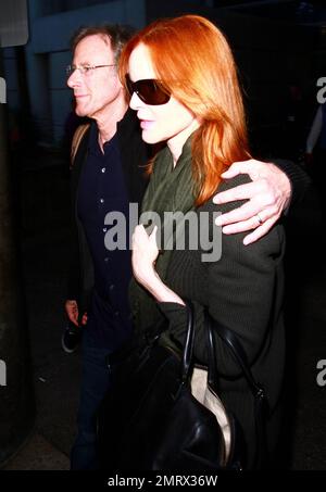Marcia Cross' husband Tom Mahoney walks with his arm around her as the two make their way through a terminal at LAX after a flight. The two looked very much the happy couple as they made their way through the airport. Cross' series 'Desperate Housewives' just came to an end. Los Angeles, CA. 21st May 2012. Stock Photo
