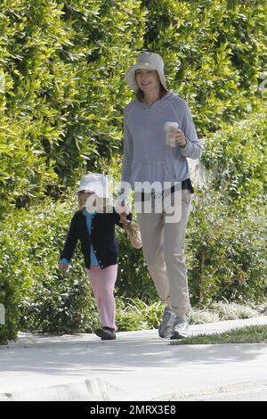 Actress Marcia Cross goes for a casual stroll with her daughter taking in the nice Sunday sun. Cross dressed down in a trendy striped pullover hoodie, rolled up khakis and she and her daughter wore matching hats.  After grabbing a coffee in her sneakers Cross later changed in to her sandals and carried a simple designer fabric and leather CŽline tote. Cross is the mother of two cute twin daughters Eden and Savannah. Los Angeles, CA. 03/13/11. Stock Photo