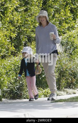 Actress Marcia Cross goes for a casual stroll with her daughter taking in the nice Sunday sun. Cross dressed down in a trendy striped pullover hoodie, rolled up khakis and she and her daughter wore matching hats.  After grabbing a coffee in her sneakers Cross later changed in to her sandals and carried a simple designer fabric and leather CŽline tote. Cross is the mother of two cute twin daughters Eden and Savannah. Los Angeles, CA. 03/13/11. Stock Photo