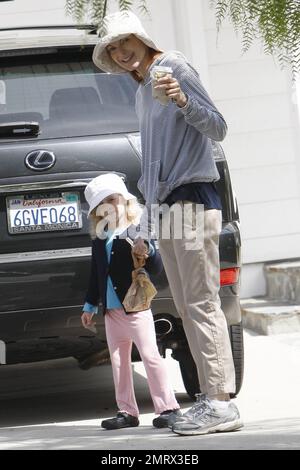 Actress Marcia Cross goes for a casual stroll with her daughter taking in the nice Sunday sun. Cross dressed down in a trendy striped pullover hoodie, rolled up khakis and she and her daughter wore matching hats.  After grabbing a coffee in her sneakers Cross later changed in to her sandals and carried a simple designer fabric and leather CŽline tote. Cross is the mother of two cute twin daughters Eden and Savannah. Los Angeles, CA. 03/13/11. Stock Photo