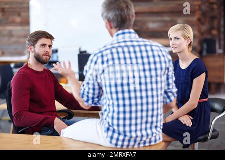 Collaborating on a design. A group of designers having an informal office meeting. Stock Photo