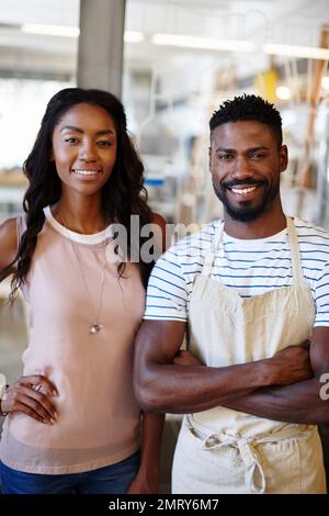 Proud of their little coffee shop. Portrait of two coffee shop owners. Stock Photo