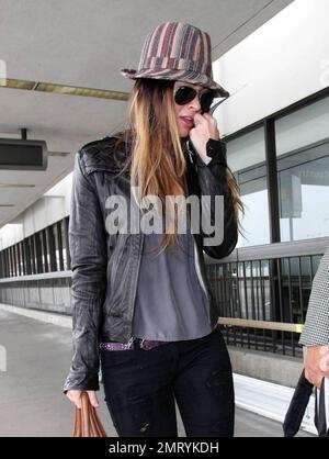 Actress Megan Fox was seen arriving at LAX this morning for a flight to New Orleans where she is filming the comic book western, 'Jonah Hex.'  Fox wore a striped fedora hat and ripped jeans.  As fox walked through the terminal she made a gesture with her pinky very reminiscent of the character Mini Me in the 'Austin Powers' films.  Los Angeles, CA.  5/9/09. Stock Photo