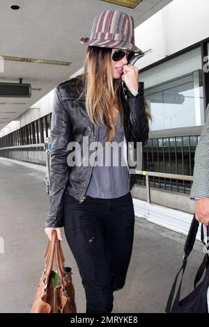 Actress Megan Fox was seen arriving at LAX this morning for a flight to New Orleans where she is filming the comic book western, 'Jonah Hex.'  Fox wore a striped fedora hat and ripped jeans.  As fox walked through the terminal she made a gesture with her pinky very reminiscent of the character Mini Me in the 'Austin Powers' films.  Los Angeles, CA.  5/9/09. Stock Photo