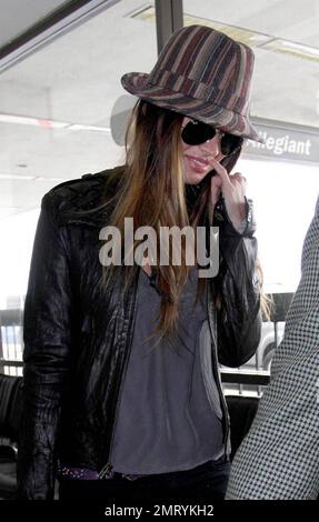 Actress Megan Fox was seen arriving at LAX this morning for a flight to New Orleans where she is filming the comic book western, 'Jonah Hex.'  Fox wore a striped fedora hat and ripped jeans.  As fox walked through the terminal she made a gesture with her pinky very reminiscent of the character Mini Me in the 'Austin Powers' films.  Los Angeles, CA.  5/9/09. Stock Photo