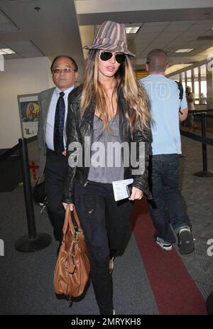 Actress Megan Fox was seen arriving at LAX this morning for a flight to New Orleans where she is filming the comic book western, 'Jonah Hex.'  Fox wore a striped fedora hat and ripped jeans.  As fox walked through the terminal she made a gesture with her pinky very reminiscent of the character Mini Me in the 'Austin Powers' films.  Los Angeles, CA.  5/9/09. Stock Photo