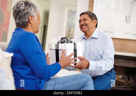 For you my darling. a loving senior man surprising his wife with a gift. Stock Photo