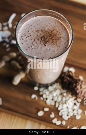 A closeup shot of a delicious chocolate shake in a tall glass cup on a wooden board Stock Photo