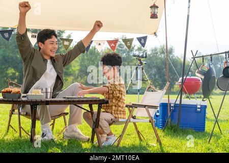 Father and son in the camp to play chess Stock Photo