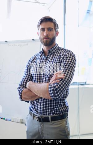 Ill get the job done for you. Cropped portrait of a handsome businessman standing with his arms crossed in the office. Stock Photo