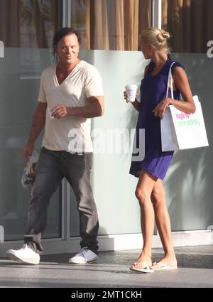 Oscar nominated actor and co-star of the upcoming 'Iron Man 2' Mickey Rourke out for a stroll along Collins Avenue with beautiful blonde girlfriend, model Anastassija Makarenko.  The couple, who looked very happy while out for some shopping, met on a photo shoot and have been dating for approximately 10 months.  Miami Beach, FL. 04/08/10. Stock Photo