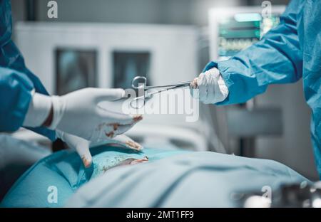 Healthcare, cutting and hands giving scissors during a surgery, hospital work and service on patient. Teamwork, help and surgeon with a tool during a Stock Photo