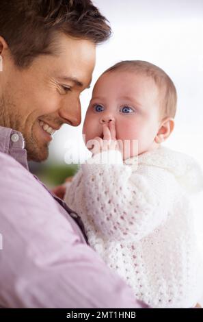 Daddys little angel. a young father holding his adorable baby daughter and showing her affection. Stock Photo