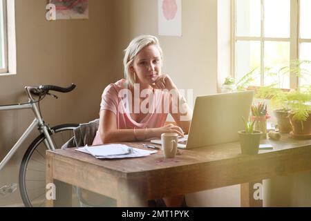 Lifes too short to have a boring job. Portrait of a female freelancer working on her laptop at home. Stock Photo